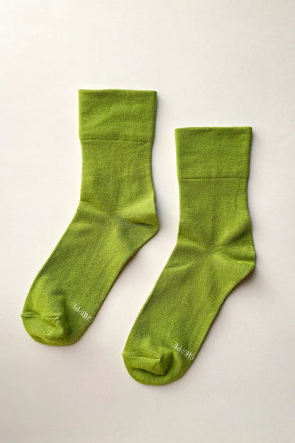 Pair of green socks on a light gray background