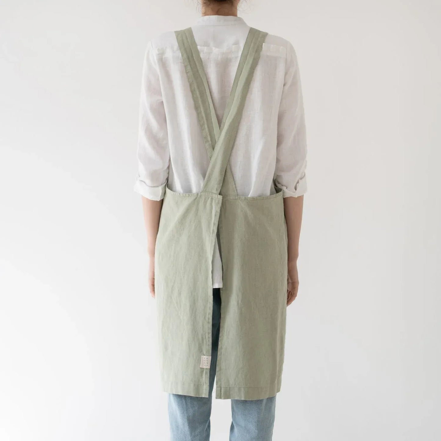 Linen crossback apron in sage colour, back profile