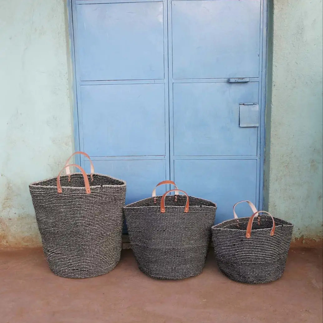 Three woven baskets with handles against a blue door.