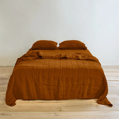 Simple Linen Quilt in Terracotta on Bed with matching colour sheets and pillow shams