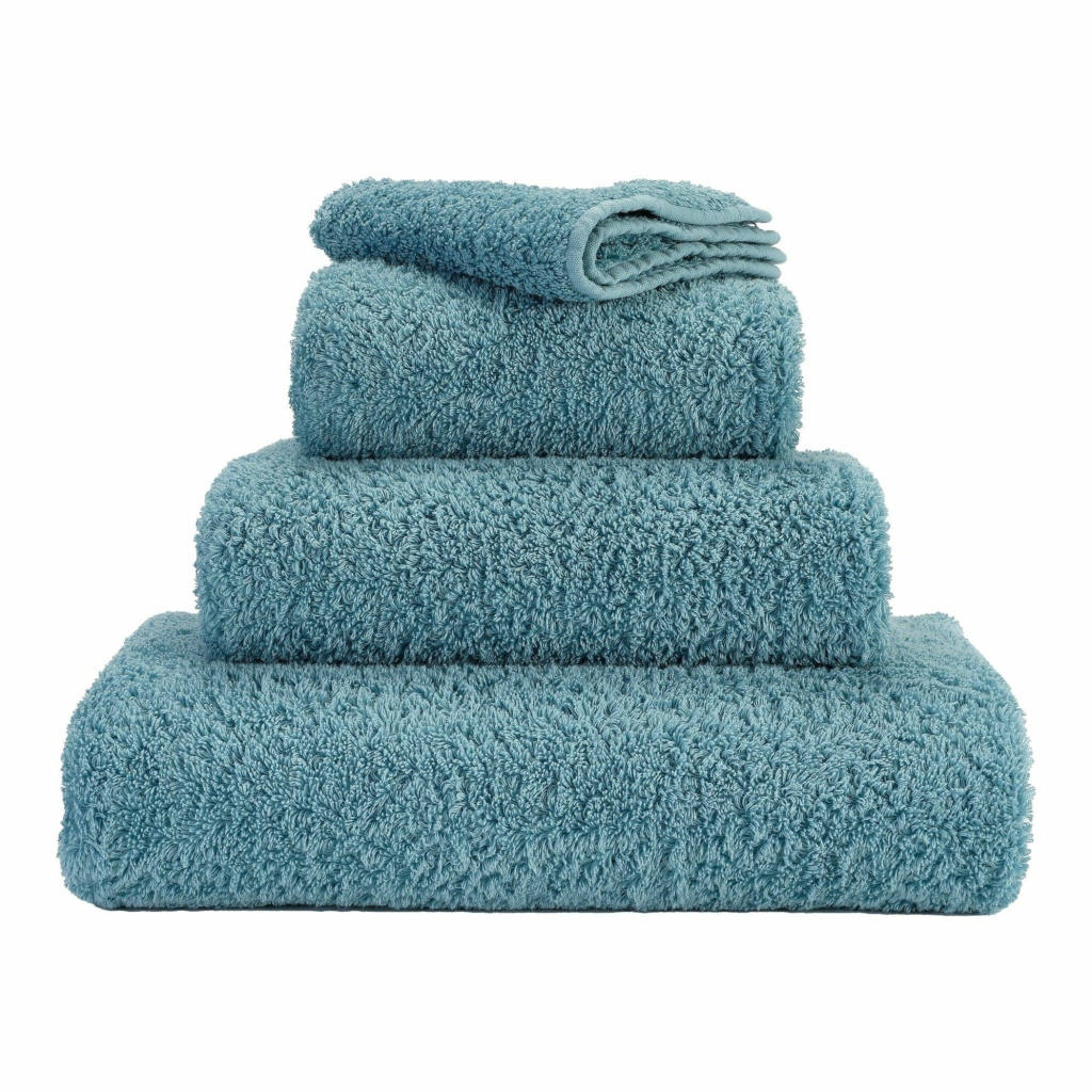 A set of blue towels neatly folded and stacked on top of each other.