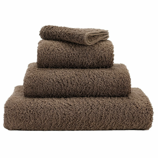 A set of dark colored bath towels made from Egyptian cotton, displayed in a stacked arrangement with a focus on the texture of the fabric.