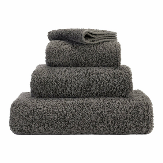 Stack of Gris 920 Abyss & Habidecor Super Pile towels in various sizes.