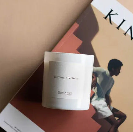 Candle labeled 'Jasmine & Vetiver' on top of a magazine with a couple on the cover.