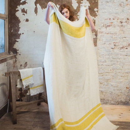 Woman holding Libeco The Belgian Towel Fouta in Mustard Stripe