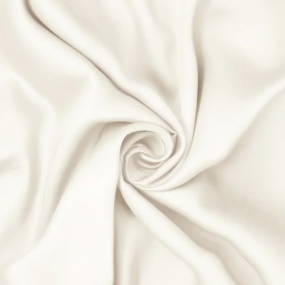 A cream sateen king-size sheet set by St. Genève, neatly presented on a bed with a brand tag visible on the fabric.
