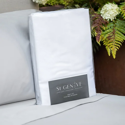 A white sateen king-size sheet set by St. Genève, neatly presented on a bed with a brand tag visible on the fabric.