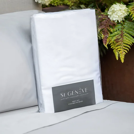 A white sateen king-size sheet set by St. Genève, neatly presented on a bed with a brand tag visible on the fabric.