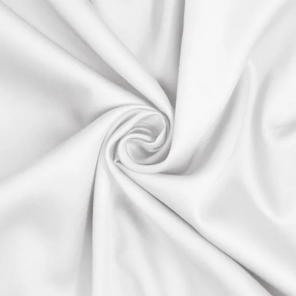A white sateen king-size sheet set by St. Genève, neatly presented on a bed with a brand tag visible on the fabric.