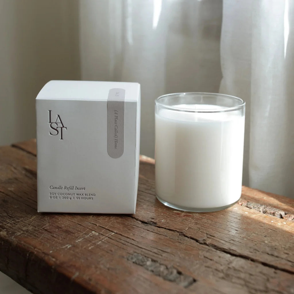 Candle and packaging on a wooden surface with a neutral background
