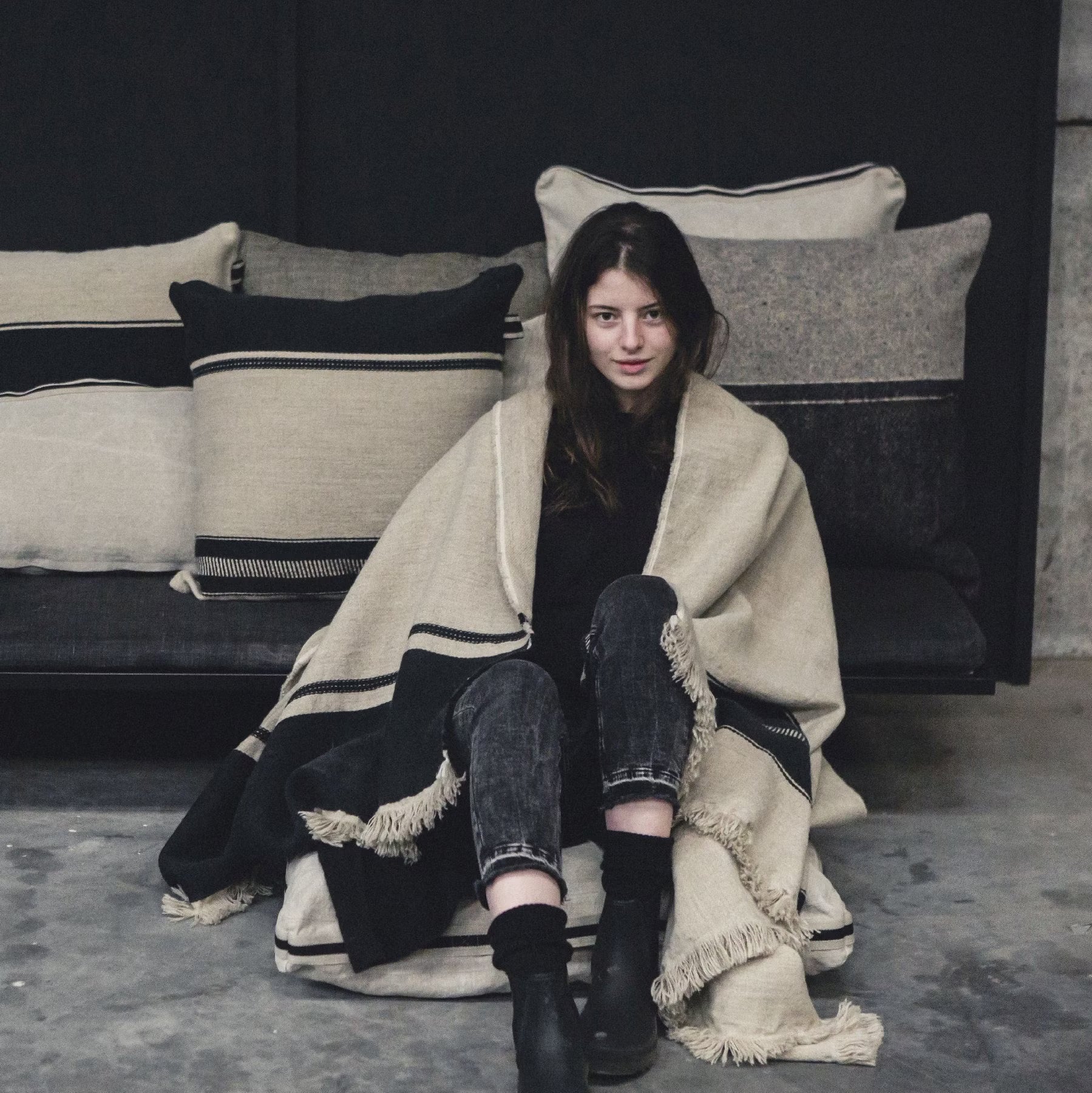 Woman sitting on the floor wrapped in LIbeco Marshall Throw