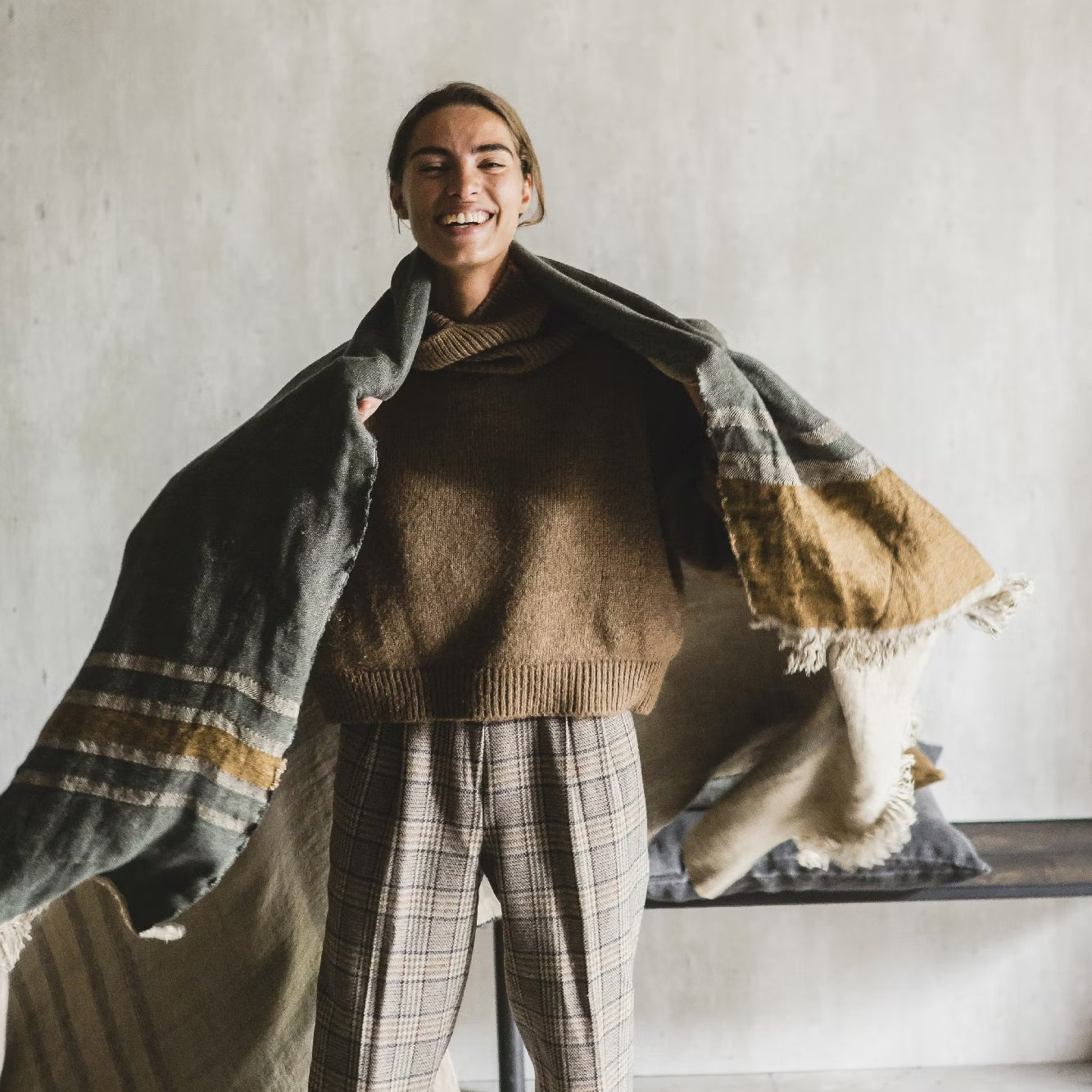 Person wearing a brown sweater and plaid pants with Libeco Belgian Towel in Alouette