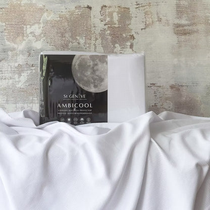A fittedAmbiCool cooling mattress protector displayed on a bed with a moon and clouds design on the packaging.