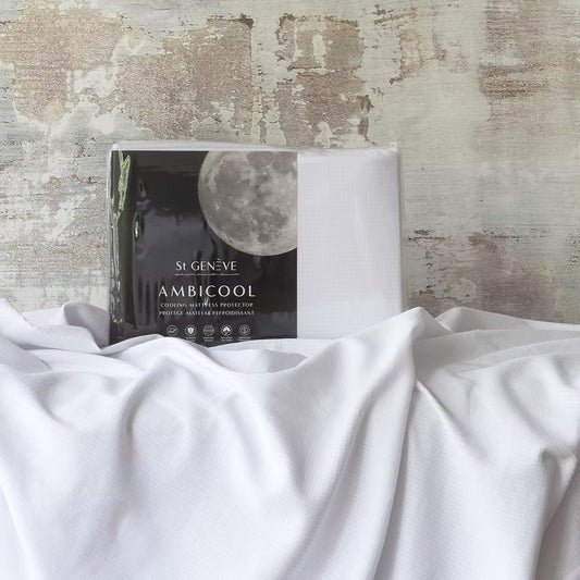 A fittedAmbiCool cooling mattress protector displayed on a bed with a moon and clouds design on the packaging.