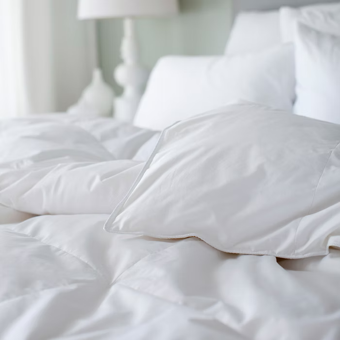 White embassy down duvet on a bed in a softly lit room