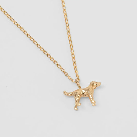 Gold dog-shaped pendant on a chain against a light gray background