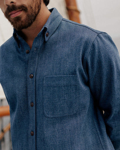 CROPPED PHOTO OF MALE MODEL WEARING DARK BLUE DENIM SHIRT, DETAIL SHOT OF COLLAR AND FRONT POCKET