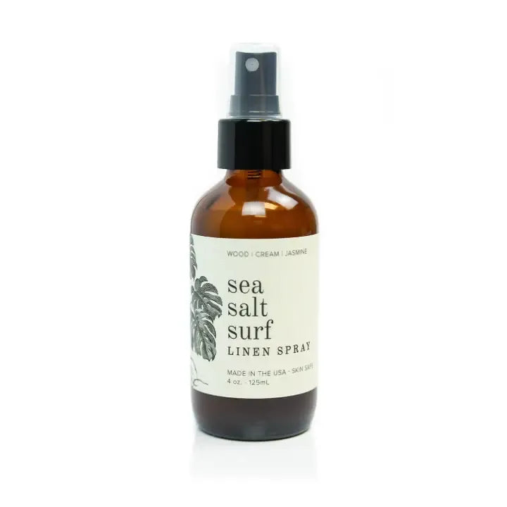 Brown spray bottle labeled 'sea salt surf linen spray' on a white background