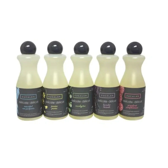 Five bottles of Eucalan laundry detergent with black caps on a white background