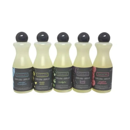 Five bottles of Eucalan laundry detergent with black caps on a white background