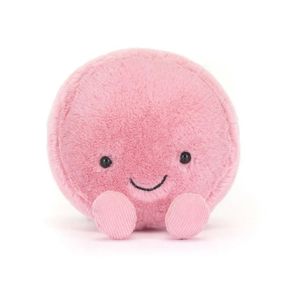 Pink plush toy with a smiling face on a white background