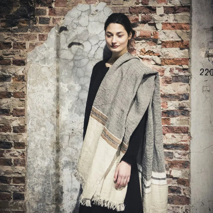 Woman wearing beeswax stripe fouta by Libeco against a brick wall