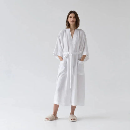 Woman wearing a white robe on a plain background