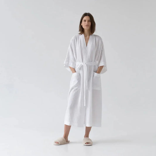 Woman wearing a white robe on a plain background