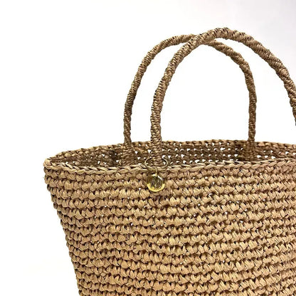 Woven straw bag with handles on a white background