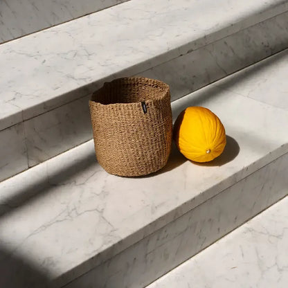 Mifuko Kiondo Basket in Brown on marble stairs