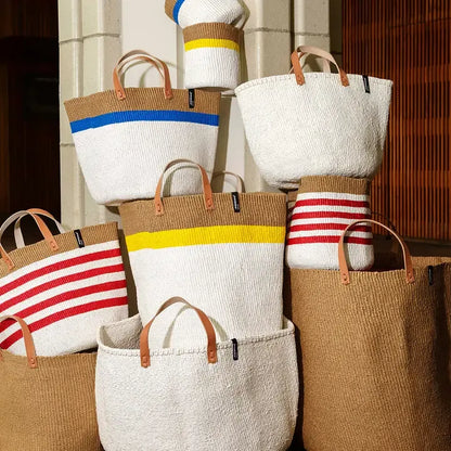 Set of woven bags with colorful stripes against a neutral background
