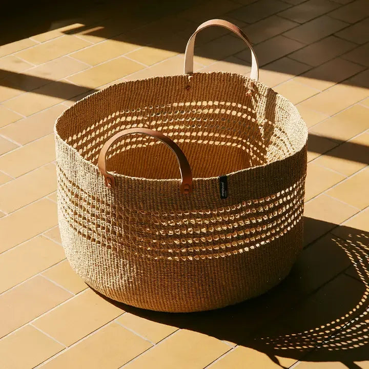 Woven basket with handles on a tiled floor
