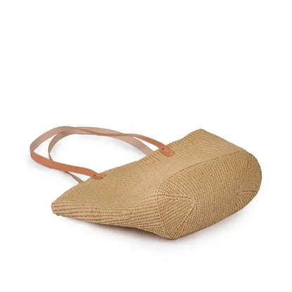 Woven handbag with leather straps on a white background