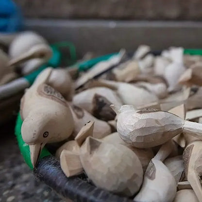Wooden bird figurines on a textured surface with blurred background