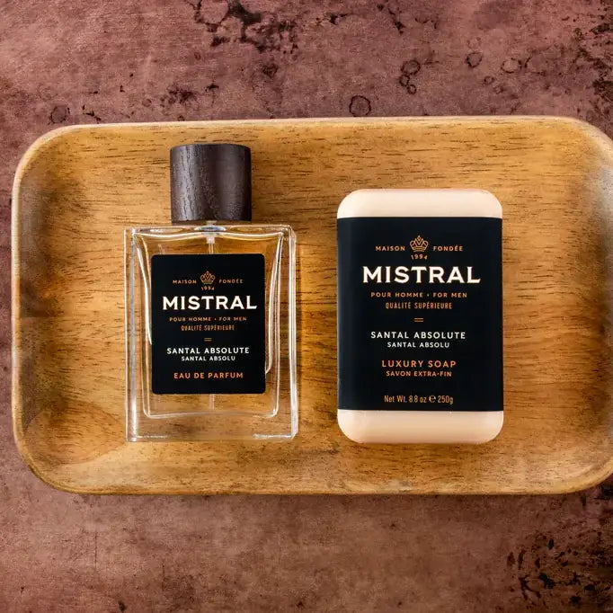 Mistral men's perfume and soap on a wooden tray with a brown background