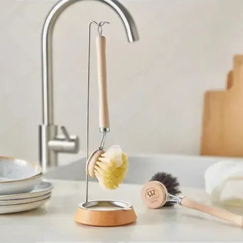 Kitchen sink area with cleaning tools and wooden cutting boards.