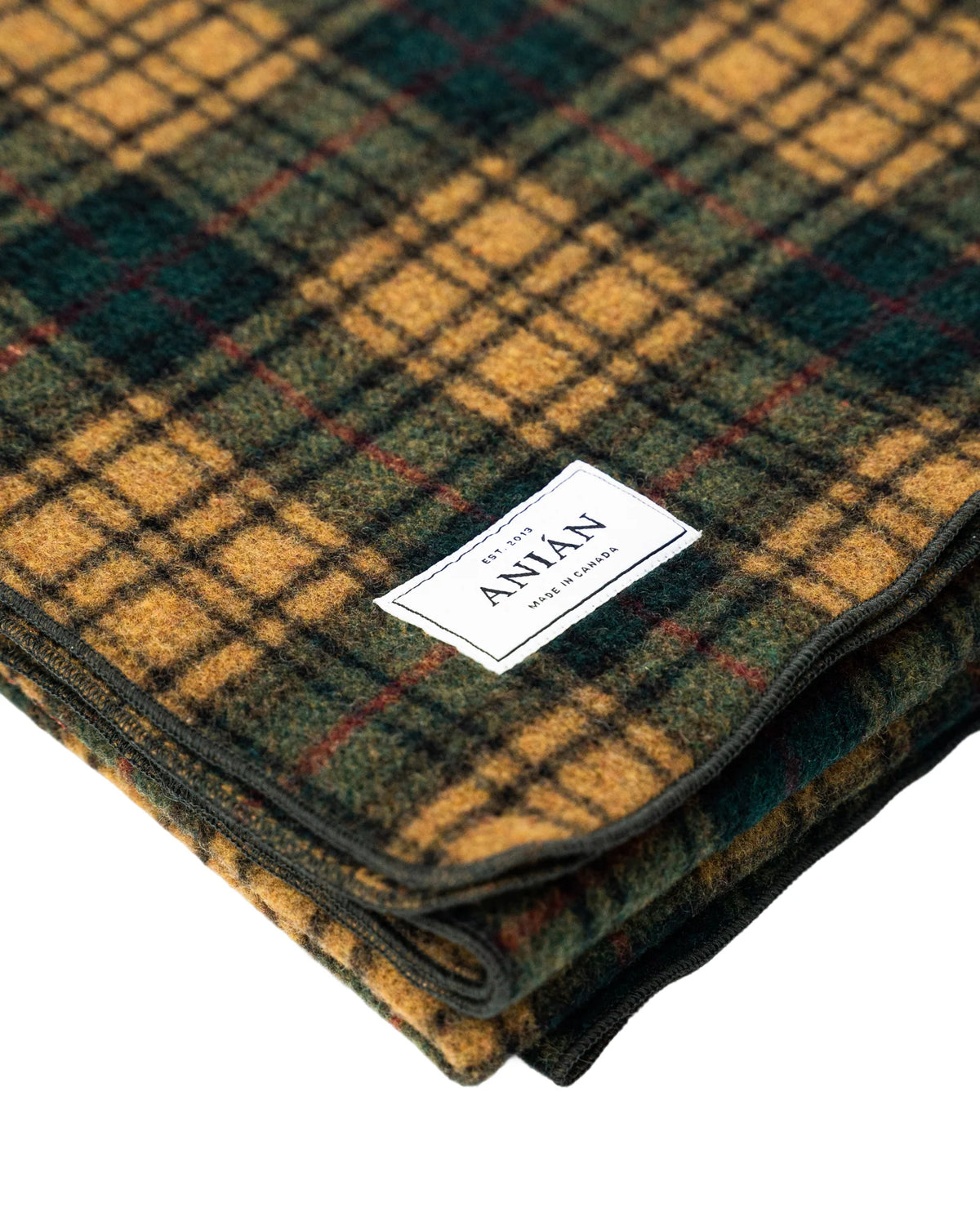 Plaid blanket with a visible brand label on a white background