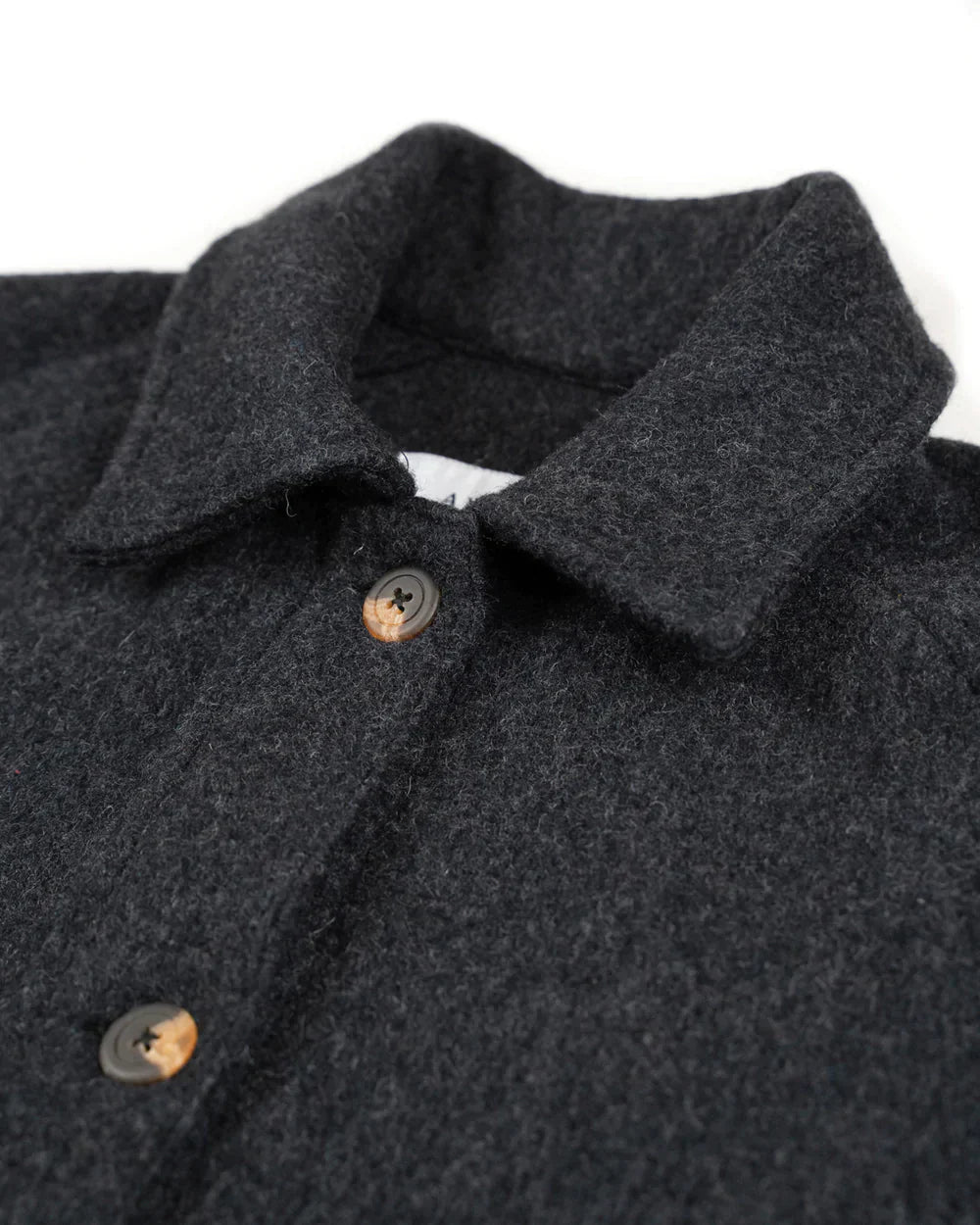 Close-up of a dark charcoal gray wool-blend collared jacket with brown buttons, showing the collar and upper chest detail against a white background.
