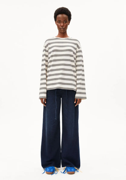 Person wearing a striped sweater and wide-leg jeans on a white background