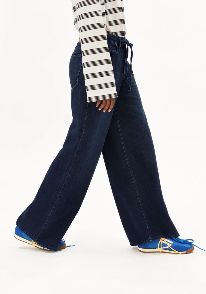 Person wearing navy wide-leg pants with a striped long-sleeve shirt on a white background