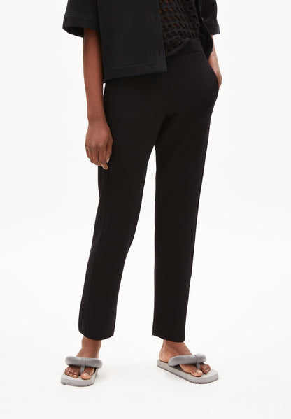 ARMEDANGELS Canada black tailored slim fit pants worn with black top and gray sandals in Kelowna