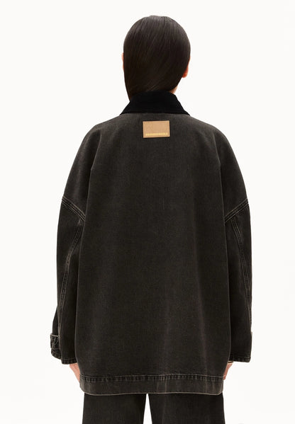 Back view of a woman wearing ARMEDANGELS Canada Denim Jacket Cord Collar, showing the oversized fit and label patch, against a white background.