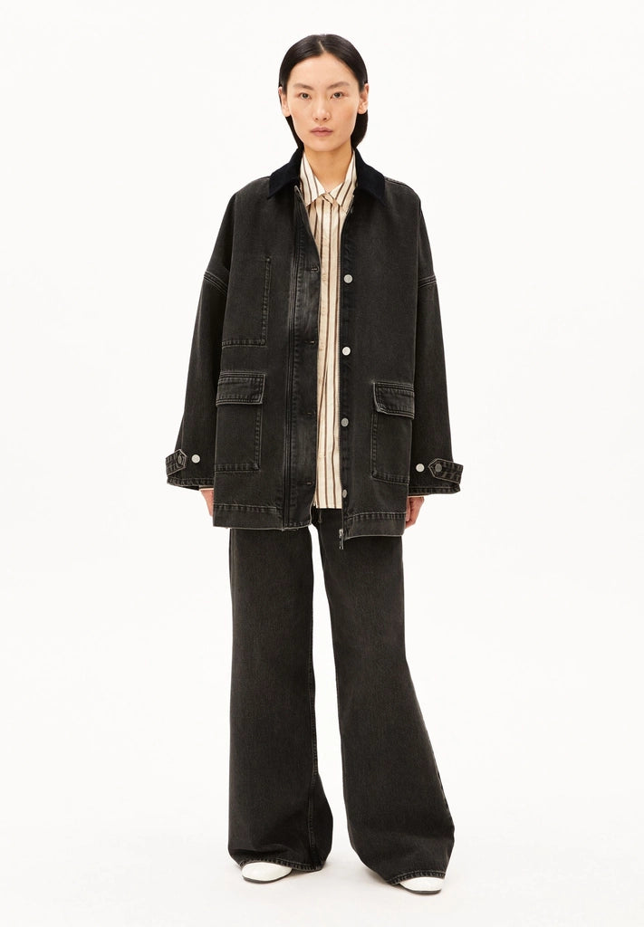 Full-length front view of a woman wearing ARMEDANGELS Canada Denim Jacket Cord Collar open over a cream shirt with wide-leg black jeans, against a white background.