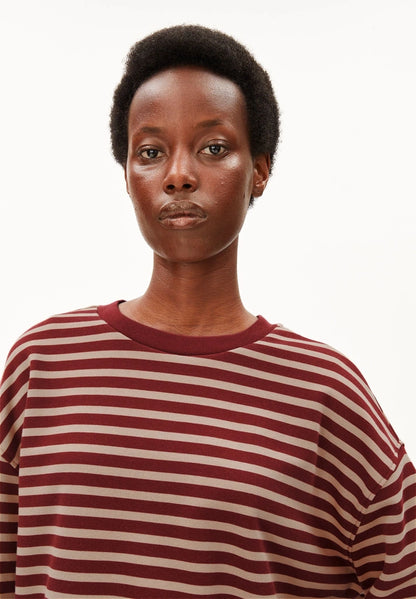 Close-up of a woman wearing ARMEDANGELS Canada Frankaa Maarlen Stripe Sweatshirt in Velvet Red-Honey Reed, showing the contrast red neckline, against a white background.