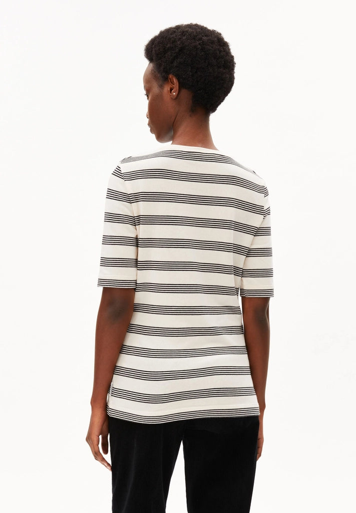 Back view of a woman wearing ARMEDANGELS Canada Jaanisara Fine Stripe T-Shirt in Oatmilk-Black with black jeans, against a white background.