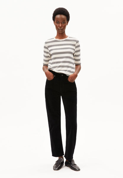 Full-length front view of a woman wearing ARMEDANGELS Canada Jaanisara Fine Stripe T-Shirt in Oatmilk-Black, tucked into black jeans with black loafers, against a white background.