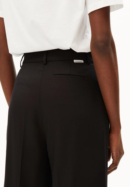Close-up of the back waistband, logo label and back welt pocket on ARMEDANGELS Canada Kaayua Wide Leg Pants in black.