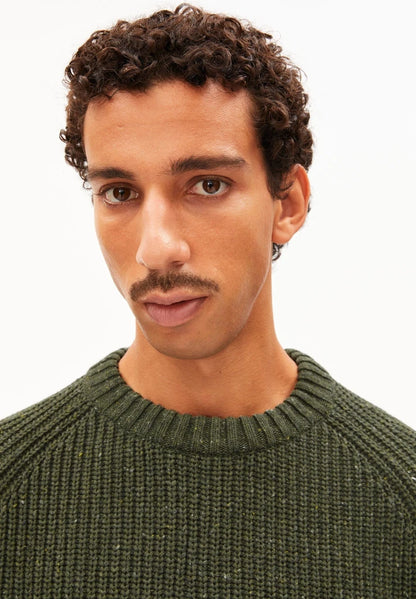 Close-up of the ribbed crew neck and flecked chunky knit on the ARMEDANGELS Canada Kiaano Tweed Knit Sweater in Dark Earth Tweed.