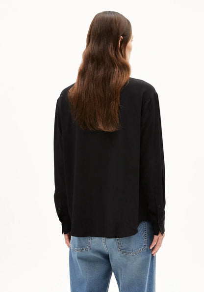 Back view of a woman wearing ARMEDANGELS Canada Larisaana Longsleeve Blouse in black, showing the relaxed fit and buttoned cuffs, against a white background.