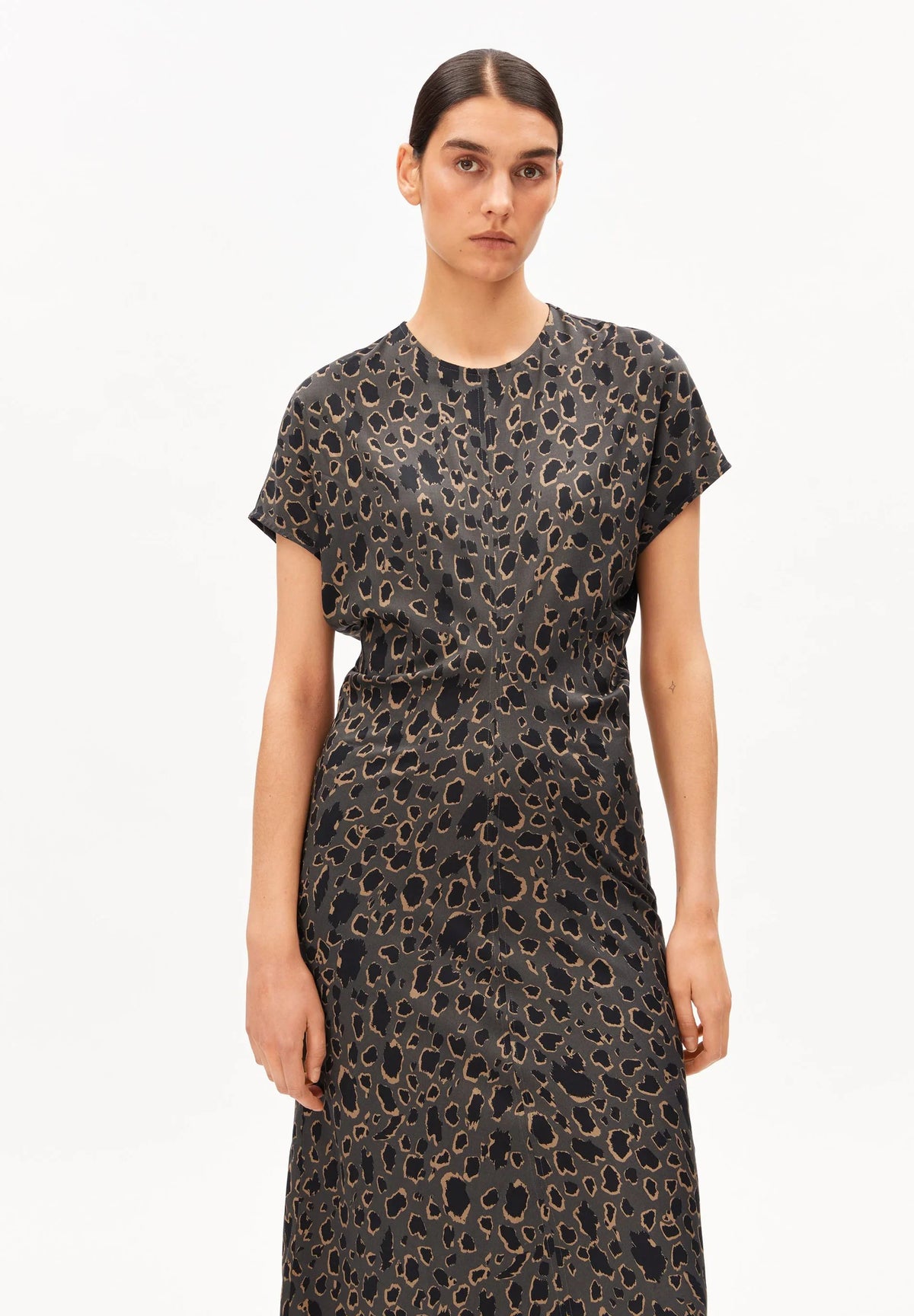 Woman wearing the ARMEDANGELS Canada Leo Bat Wing Midi Dress in a grey and black leopard print, front view on a white background.